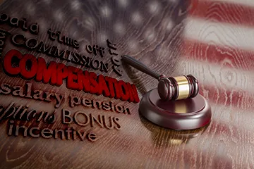 A gavel on the U.S. flag with words related to judge's compensation.