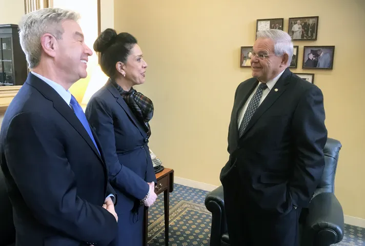 Judge Esther Salas speaks with Senator Bob Menendez, who cosponsored the legislation to protect judges. Salas’s husband, Mark Anderl (left), was wounded during a July 2020 attack at their home in New Jersey.